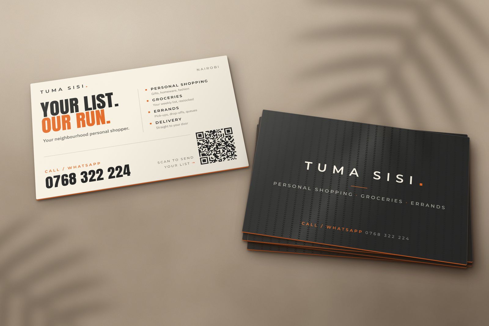 Tuma Sisi business cards: a cream card listing services with a WhatsApp QR code, and a stack of charcoal cards with orange edges.